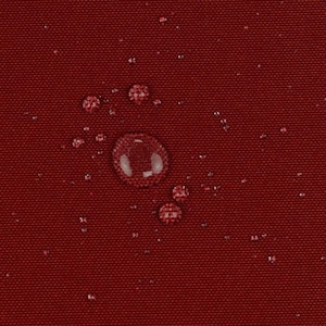 May include: A deep red, tightly woven fabric surface featuring a water-repellent finish. Multiple clear water droplets of varying sizes are scattered across the textured material, creating a beaded effect on the dark crimson textile background.