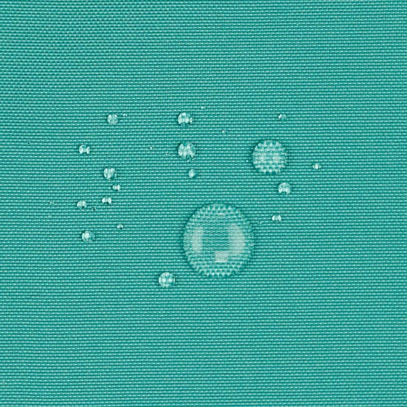 May include: A solid teal fabric with a tight, woven texture. Several clear water droplets of varying sizes are scattered across the surface, resting on top of the material without being absorbed into the tightly knit synthetic fibers.