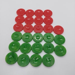 May include: A set of 20 round game pieces, 10 are red and 10 are green. The pieces are arranged in a pyramid shape with the red pieces on top.