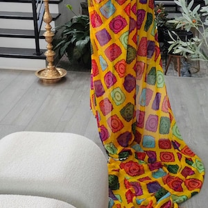 Yellow bandhini print georgette saree with contrast green stitched blouse with fine muted gold lace detail blouse size 40 with margin