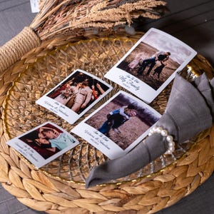 K&ouml;nnte beinhalten: Vier Sofortbild-Fotos mit wei&szlig;en R&auml;ndern und Text auf einem geflochtenen Platzdeckchen mit einem Glasteller und einer grauen Serviette mit einem Perlenring. Die Fotos zeigen ein Paar, eine Familie und zwei Kinder.
