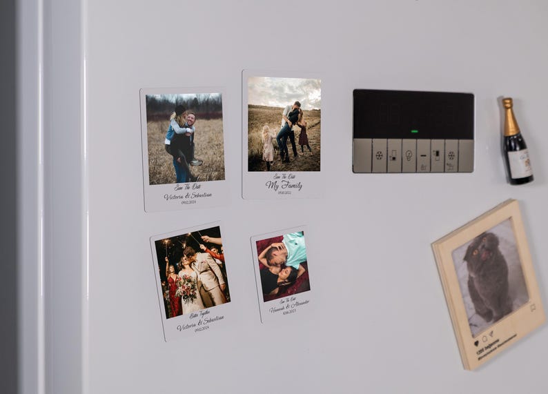 K&ouml;nnte beinhalten: Vier wei&szlig;e Foto-Karten mit schwarzen R&auml;ndern und dem Text "Save the Date" und "My Family" mit Fotos eines Paares und einer Familie. Die Karten befinden sich auf einem wei&szlig;en K&uuml;hlschrank mit einem schwarzen Bedienfeld und einem kleinen Holzrahmen mit einem Foto eines Hundes.