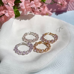 Könnte beinhalten: Drei zarte Ringe aus Draht und kleinen, klaren, schillernden Perlen. Die Ringe sind in Silber, Gold und einer Kombination aus Silber und Gold.