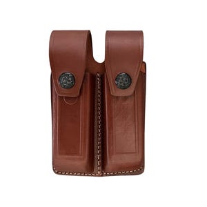 May include: A brown leather double magazine pouch with snap closures.