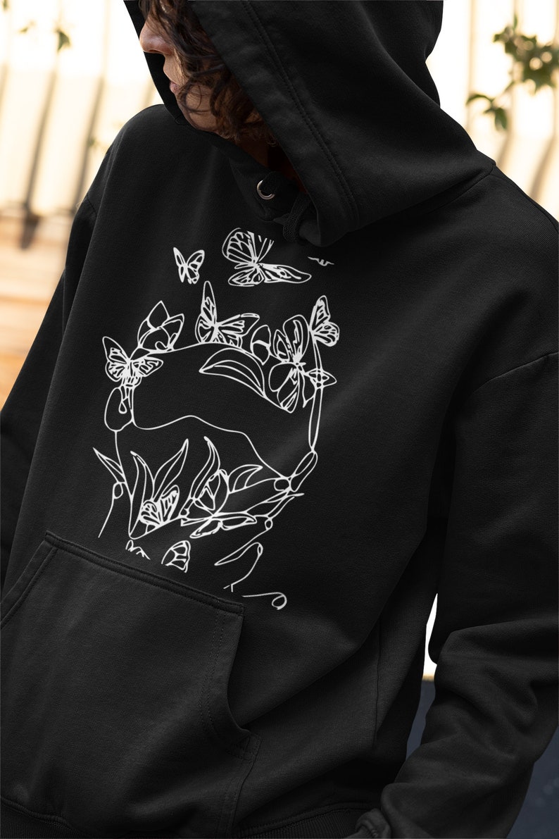 May include: Black hoodie with a white line drawing of hands holding flowers and butterflies.
