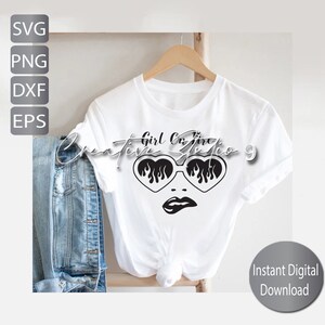 Op de afbeelding: Wit T-shirt met een afbeelding van een gezicht met hartvormige zonnebrillen met vlammen. De tekst "Creative Girl On Fire 9" staat boven de afbeelding. Een spijkerjasje hangt links. De woorden "SVG, PNG, DXF, EPS" staan links.