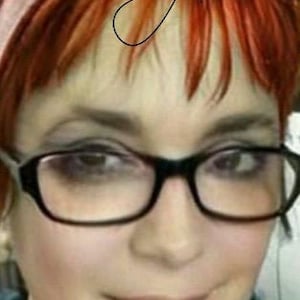 May include: A close-up portrait of a person with red-orange hair and black-framed glasses. The person is smiling slightly. The word "Celestyn" is written in cursive at the top of the image.