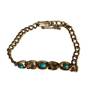 Puede incluir: Un brazalete de cadena de oro con acentos turquesa y perla.