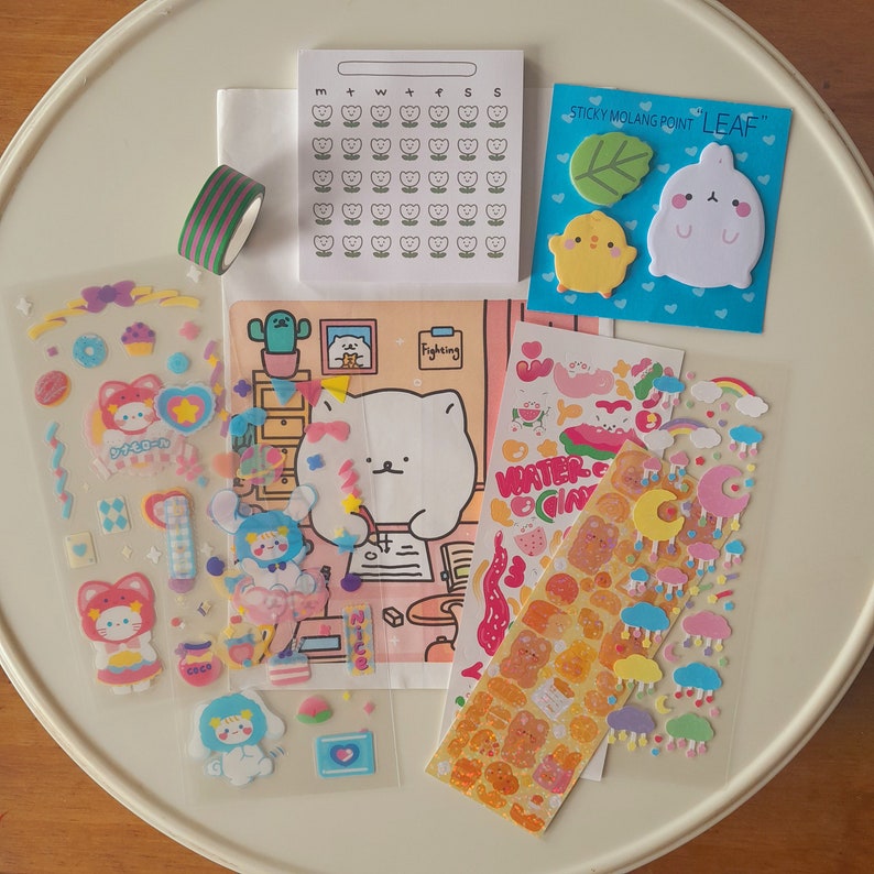 Puede incluir: Un conjunto de pegatinas coloridas con animales de dibujos animados, corazones, estrellas y nubes. Las pegatinas est&aacute;n sobre un fondo blanco y son perfectas para decorar planificadores, diarios y otros art&iacute;culos.