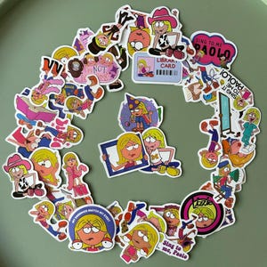May include: A selection of vibrant stickers showcasing cartoon images of a blonde girl in different poses and attire. Text on some stickers reads "Sing to me, Paolo" and "My earrings match my eyes?" The stickers are displayed on a green background.