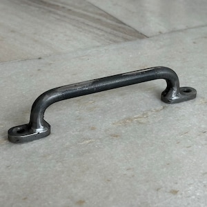 May include: A black metal door handle with a rounded shape. The handle is designed for pulling open doors.