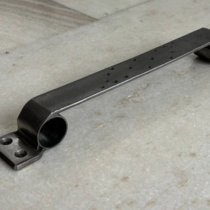 Op de afbeelding: Een zwarte metalen deurgreep met een getextureerd oppervlak en afgeronde uiteinden. De greep is ontworpen voor een schuifdeur.