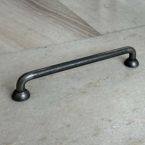 Peut inclure: Une poignée de tiroir en métal noir avec des extrémités arrondies. La poignée mesure environ 15 cm de long.