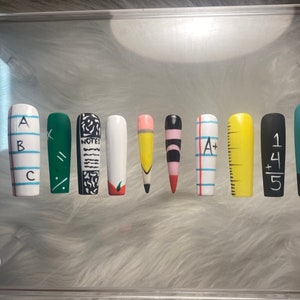 May include: Ten painted fingernails with different school-themed designs. The designs include letters, a pencil, a ruler, a notebook, and maths equations.