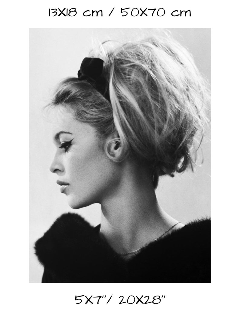 May include: Black and white portrait photograph of a woman with her hair styled in a bouffant. She is wearing a black fur collar and a black headband.