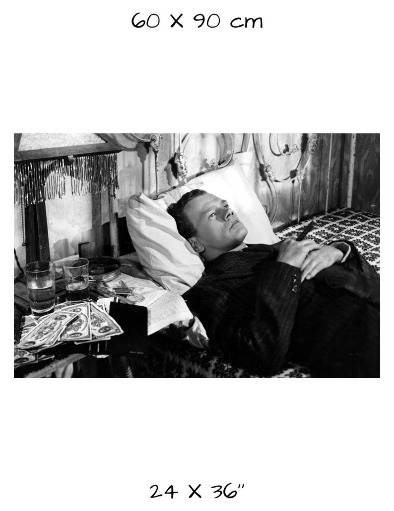 K&ouml;nnte beinhalten: Schwarzwei&szlig;foto eines Mannes, der im Bett liegt. Er tr&auml;gt einen Anzug und hat die H&auml;nde auf der Brust gefaltet. Neben ihm auf dem Nachttisch stehen Gl&auml;ser und Geld. Das Bild ist 60 x 90 cm oder 24 x 36 Zoll gro&szlig;.