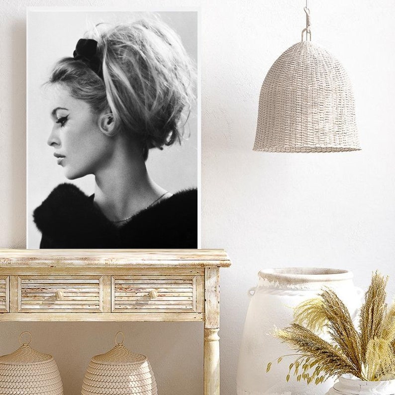 May include: Black and white portrait photograph of a woman with her hair styled in a bouffant and a black headband. The woman is looking to the side and wearing a fur collar.