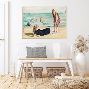 May include: A painting of two women on a beach. One woman is lying down on the sand, while the other is standing and looking at her. The water is in the background, and there are other people swimming in the water.
