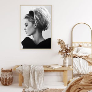 May include: Black and white portrait photograph of a woman with a bouffant hairstyle. The woman is wearing a fur collar and looking to the side.