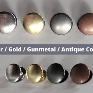 May include: Four round metal buttons in different finishes: silver, gold, gunmetal, and antique copper. The buttons are arranged in two rows of two.