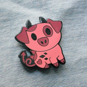 May include: A pink pig with black horns and a tail, with a black heart and diamond pattern on its body. The pig has a black eye and a black snout.