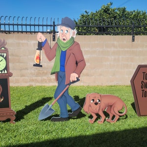 May include: A Halloween yard decoration set featuring a man with a lantern and shovel, a dog, a clock with a monster face, and a tombstone that reads "Tomb Sweet Tomb".