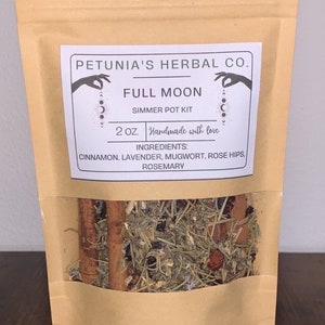 May include: A brown paper bag with a clear window showing a mix of dried herbs and spices. The bag has a white label that reads "PETUNIA'S HERBAL CO. FULL MOON SIMMER POT KIT 2 OZ. Handmade with love INGREDIENTS: CINNAMON, LAVENDER, MUGWORT, ROSE HIPS, ROSEMARY"