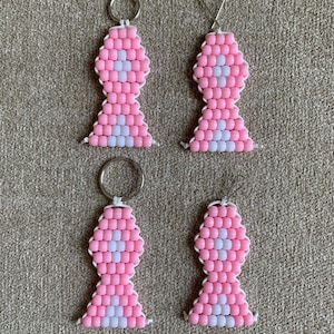 May include: Four pink and white beaded ribbon keychains. The ribbons are shaped like awareness ribbons and have a white center.