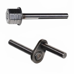 May include: Two metal mechanical components are displayed against a white background. The top piece has a hexagonal head and a cylindrical shaft. The bottom piece has a bent shape with two cylindrical shafts connected by a welded plate.