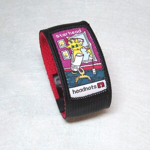 May include: Black wristband with a red strap and a colorful patch that says "Starhead" and "headnots n".