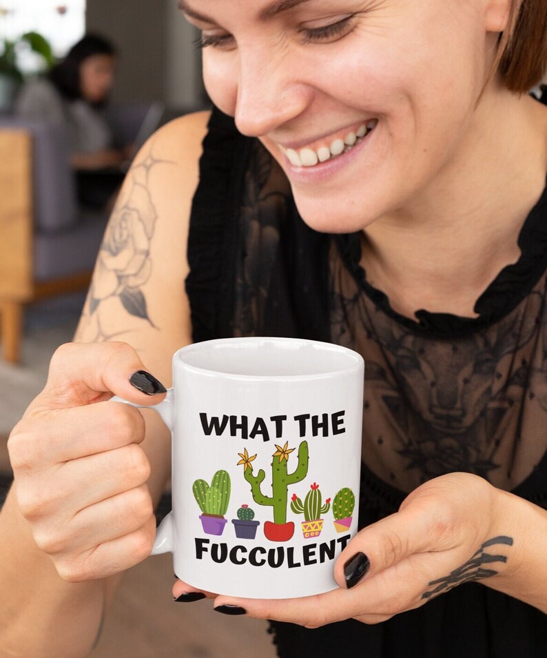 May include: White ceramic mug with a green cactus graphic and the text "What the Fuccolent".