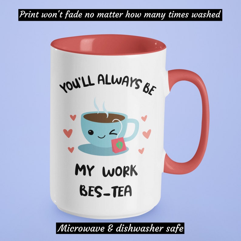 May include: White ceramic mug with a red rim and handle. The mug has a cartoon illustration of a teacup with a smiling face and the text "You'll always be my work bes-tea". The text "Microwave & dishwasher safe" is printed on the bottom of the mug.