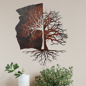 May include: Metal wall art sculpture of a tree with roots and branches. The tree is made of two pieces of metal, one with a rusty brown finish and the other with a white finish. The tree is mounted on a white wall.