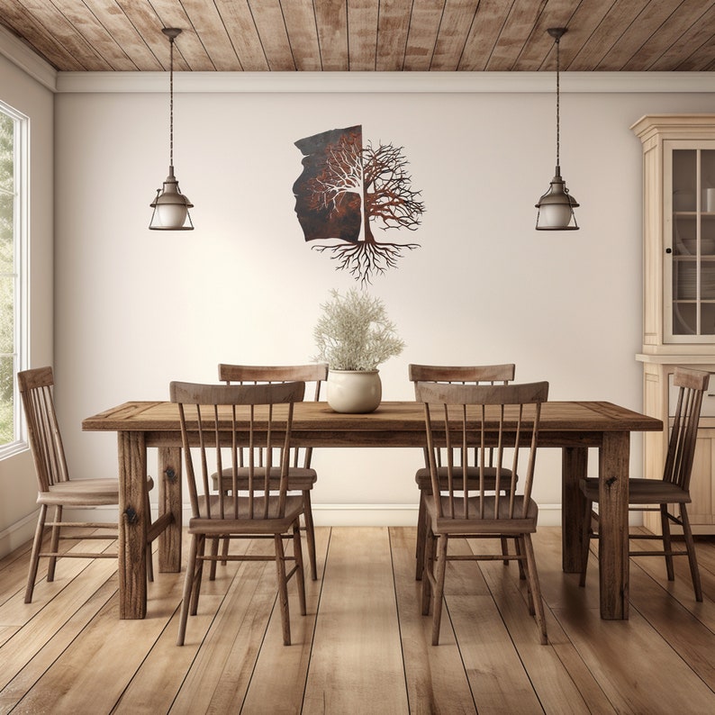 May include: A rustic wooden dining table with six chairs, set in a room with a white wall and wooden ceiling. A metal tree sculpture hangs on the wall above the table.