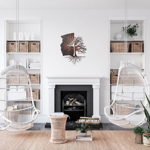 May include: A white wicker hanging chair with a metal tree sculpture on the wall behind it. The tree sculpture is made of metal and has a brown and black finish. The chair is hanging from the ceiling and is in a living room setting.