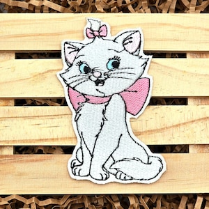 May include: White embroidered iron-on patch of a cartoon cat with pink bow, blue eyes, and a white background.