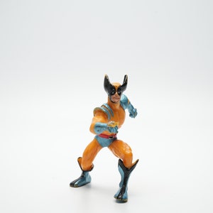 Può includere: Una action figure gialla e blu di Wolverine, un supereroe dei fumetti degli X-Men, in posa da combattimento.