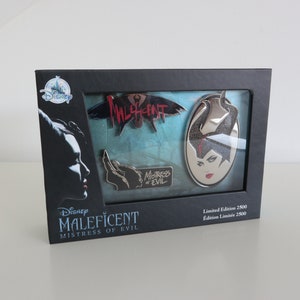 Op de afbeelding: Een zwarte doos met een transparant plastic venster waarin vier Maleficent-pins te zien zijn. Op de doos staat "Disney Maleficent Mistress of Evil" en "Limited Edition 2500".