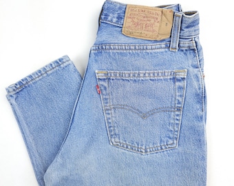 May include: Light blue denim jeans with a back pocket and a Levi's label that reads "Levi's 501-550-0217" and "Original  Levi's  Quality  Clothing".