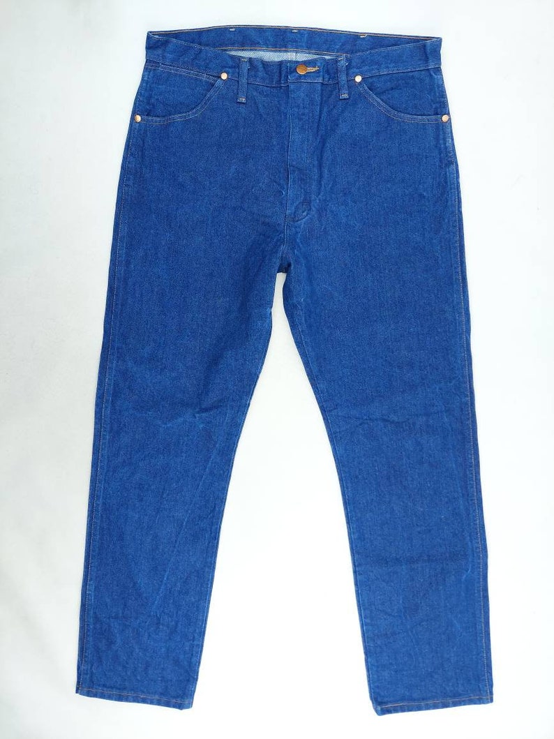 May include: A pair of blue denim jeans with a straight leg fit. The jeans have a classic five-pocket design and a button fly.