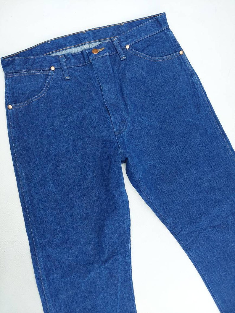 May include: A pair of blue denim jeans with a classic five-pocket style. The jeans have a straight leg and a relaxed fit.