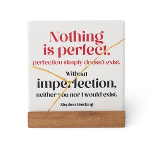 May include: White ceramic square with a gold crack running through it. The text reads "Nothing is perfect. Perfection simply doesn't exist. Without imperfection, neither you nor I would exist. Stephen Hawking."