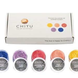 Op de afbeelding: Een set van vijf kleine potjes micapoeder in tinten blauw, paars, rood, roze en geel. De potjes zijn gelabeld met de namen "Wild Lupin", "Lilac Wine", "Watermelon Cooler", "Pink Pomelo" en "Amalfi Lemon". De potjes zijn in een rij op een wit oppervlak gerangschikt. De tekst "CHIYU" is op de potjes en op de doos gedrukt. De doos is gelabeld met "Premium micapoeder set SUMMER SUNSET".