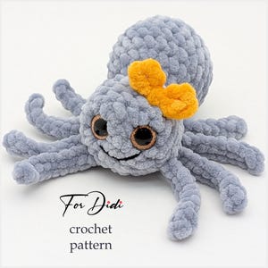 Puede incluir: Un pulpo de ganchillo gris con grandes ojos brillantes y un lazo naranja. El texto "For Didi crochet pattern" está escrito en cursiva debajo.