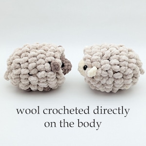 K&ouml;nnte beinhalten: Zwei handgefertigte, pl&uuml;schige Schafspielzeuge in hellbeiger Farbe. Die Schafe haben ein strukturiertes, wolliges Aussehen mit dunkelbraunen Akzenten an Kopf und Ohren. Der Text "wool crocheted directly on the body" steht darunter.
