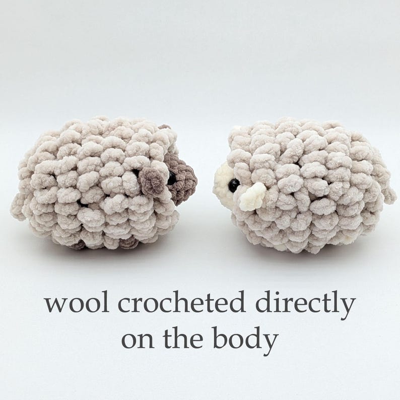 K&ouml;nnte beinhalten: Zwei handgefertigte, pl&uuml;schige Schafspielzeuge in hellbeiger Farbe. Die Schafe haben ein strukturiertes, wolliges Aussehen mit dunkelbraunen Akzenten an Kopf und Ohren. Der Text "wool crocheted directly on the body" steht darunter.