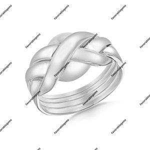 Könnte beinhalten: Ein silberner, ineinandergreifender Puzzlerring mit glatter, polierter Oberfläche. Der Ring besteht aus mehreren Bändern, die miteinander verschlungen sind, um ein einzigartiges und kompliziertes Design zu schaffen.