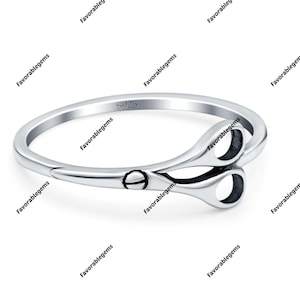 May include: A silver ring with a detailed design of a pair of scissors. The ring is marked with "S925", indicating it is made of sterling silver.