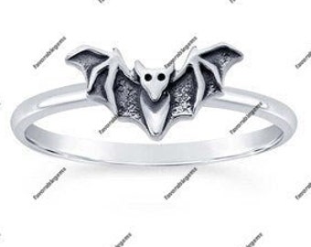 May include: A silver ring with a detailed bat design. The bat is facing forward with its wings spread out.