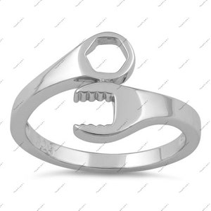 May include: A silver ring shaped like a wrench. The ring is open and has a smooth, polished finish.
